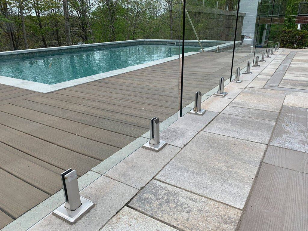 Garde-corps de verre entre la terrasse de bois et la piscine